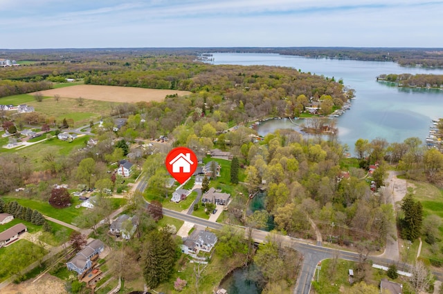 aerial overview of property's location featuring a large body of water and a heavily wooded area