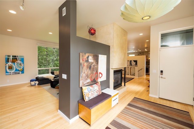 hallway featuring wood finished floors, recessed lighting, and baseboards
