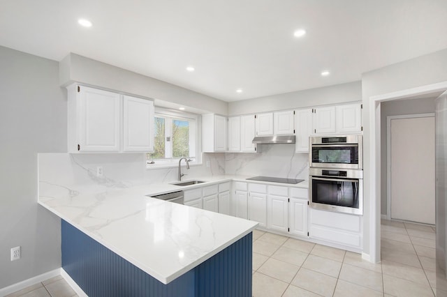 1204 Bradbury Dr, Troy, MI 48098 - kitchen with under cabinet range hood, appliances with stainless steel finishes, a peninsula, light stone counters, and tasteful backsplash