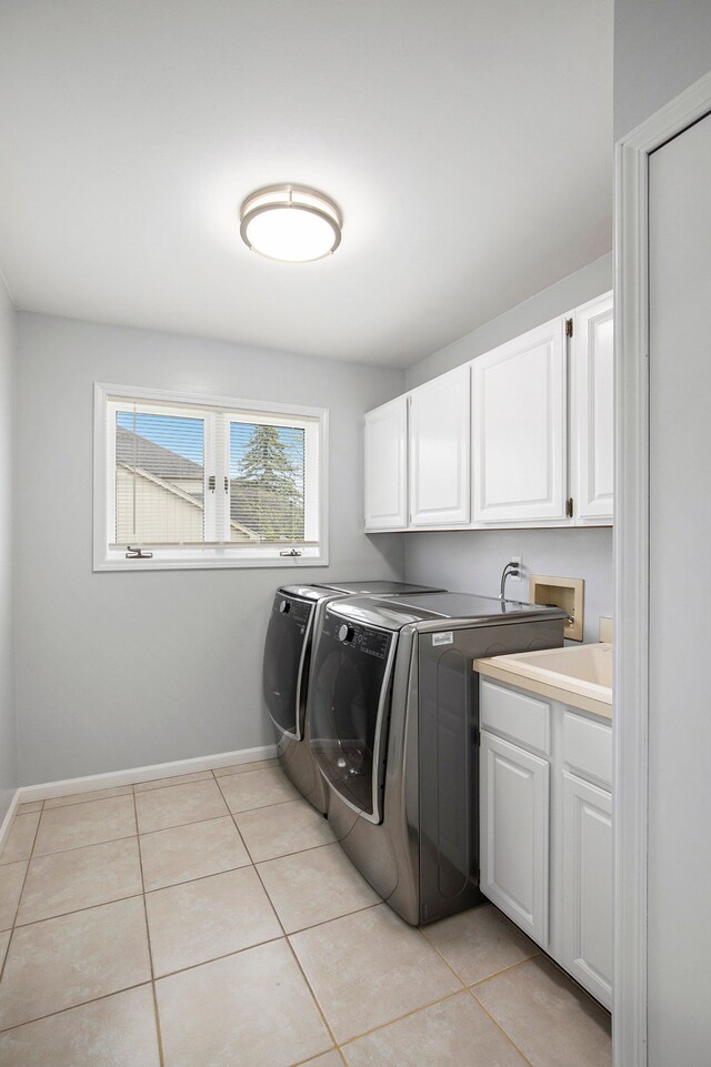 1204 Bradbury Dr, Troy, MI 48098 - clothes washing area featuring cabinet space, washer and dryer, light tile patterned flooring, and baseboards