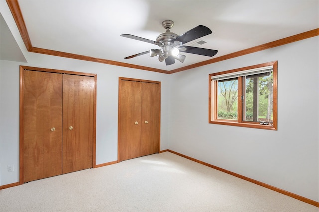 1204 Bradbury Dr, Troy, MI 48098 - unfurnished bedroom with two closets, baseboards, light carpet, crown molding, and a ceiling fan