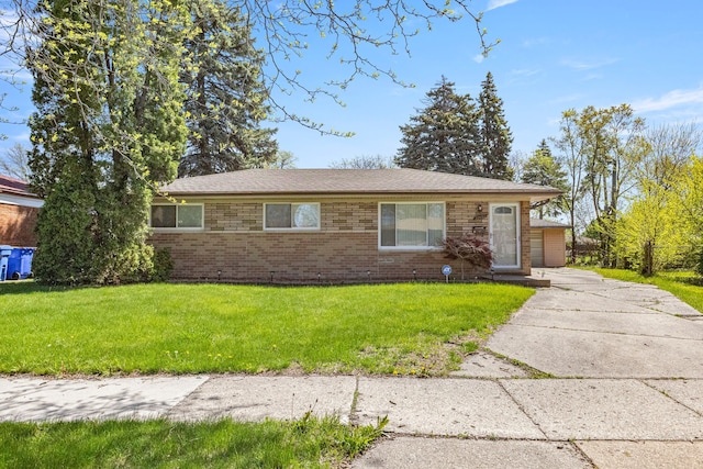 view of front of house featuring brick siding and a front yard
