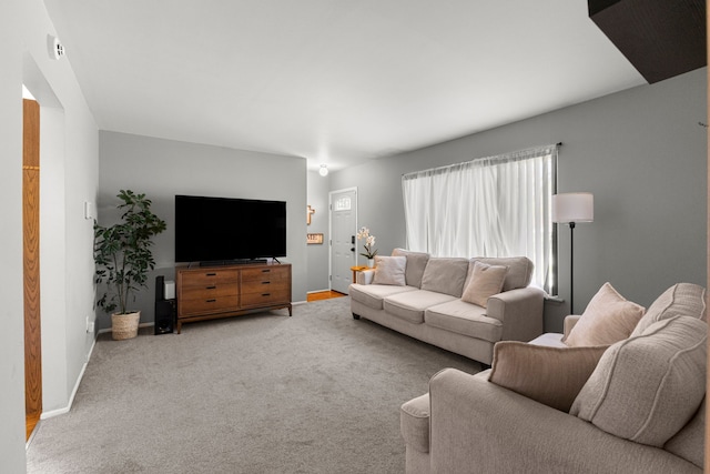 living area with baseboards and light carpet