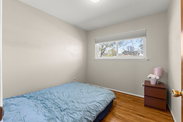 bedroom with wood finished floors and baseboards