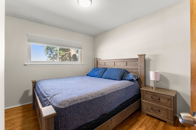 bedroom featuring wood finished floors and baseboards