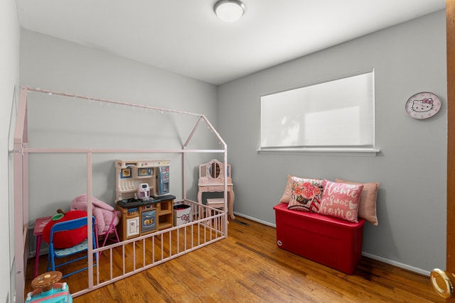 recreation room featuring wood finished floors and baseboards