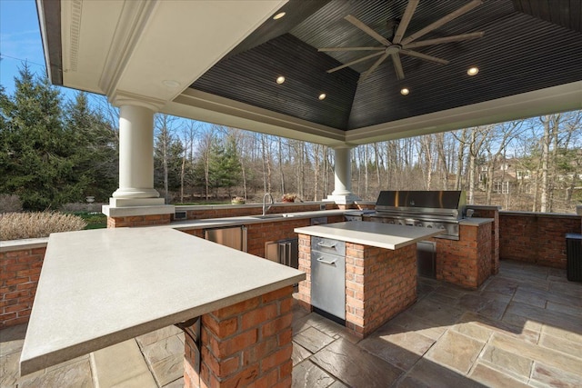 view of patio featuring a grill, exterior kitchen, ceiling fan, and a sink
