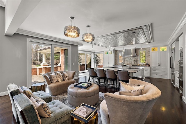 living area with ornamental molding, baseboards, dark wood-type flooring, and healthy amount of natural light