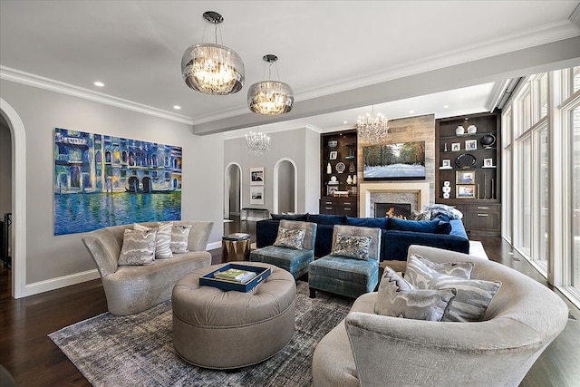 living area with arched walkways, a chandelier, baseboards, wood finished floors, and recessed lighting