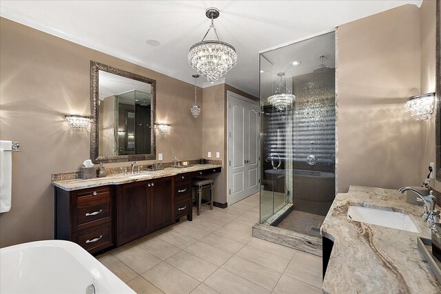 bathroom with a chandelier, two vanities, a shower stall, tile patterned floors, and a freestanding bath