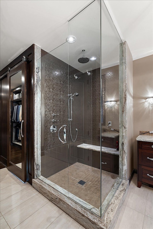 full bathroom featuring a shower stall, vanity, and tile patterned flooring