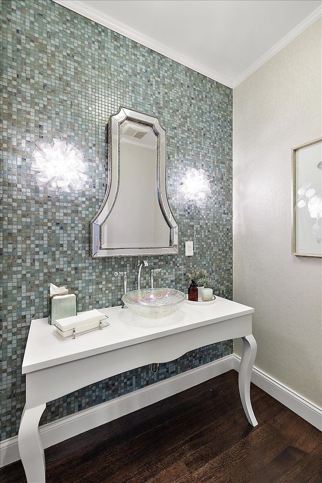 bathroom featuring ornamental molding, wood finished floors, vanity, and baseboards