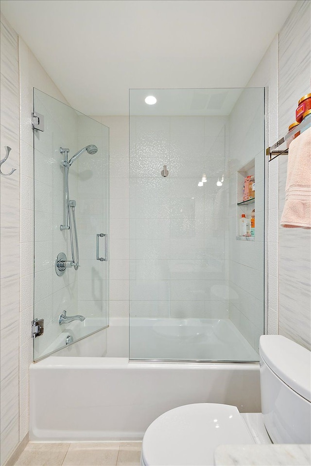 full bath featuring toilet, combined bath / shower with glass door, and tile patterned floors