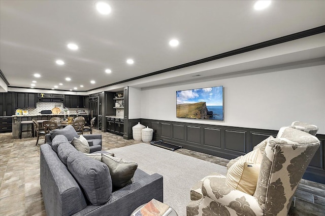 home theater featuring crown molding, recessed lighting, a wainscoted wall, and a tray ceiling
