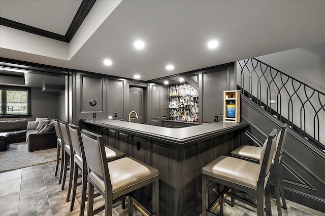 indoor wet bar featuring a decorative wall, ornamental molding, stairway, and recessed lighting