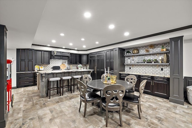 dining room with ornamental molding, recessed lighting, and bar area