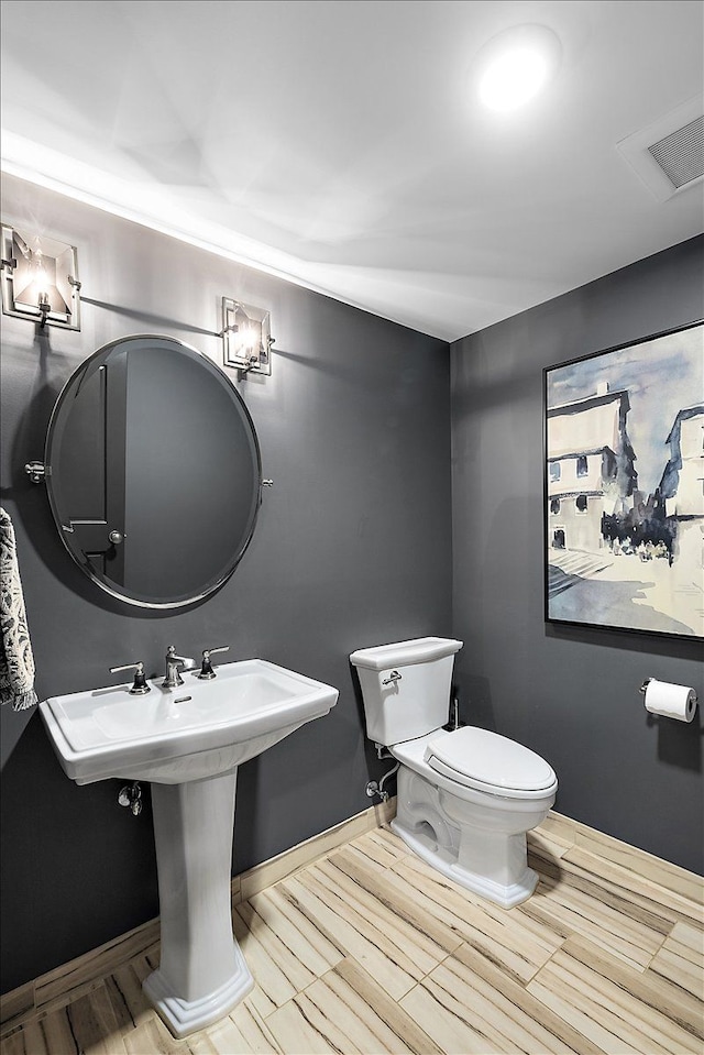 bathroom featuring toilet and wood tiled floors