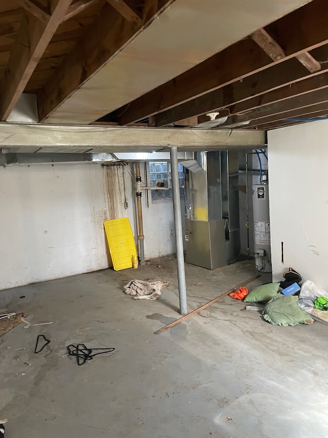 unfinished basement with gas water heater and heating unit