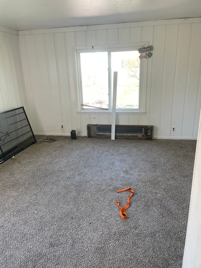 carpeted spare room with a decorative wall