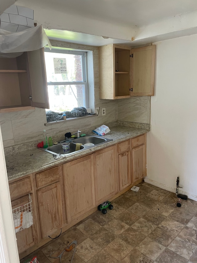 kitchen with a sink, open shelves, decorative backsplash, and light countertops