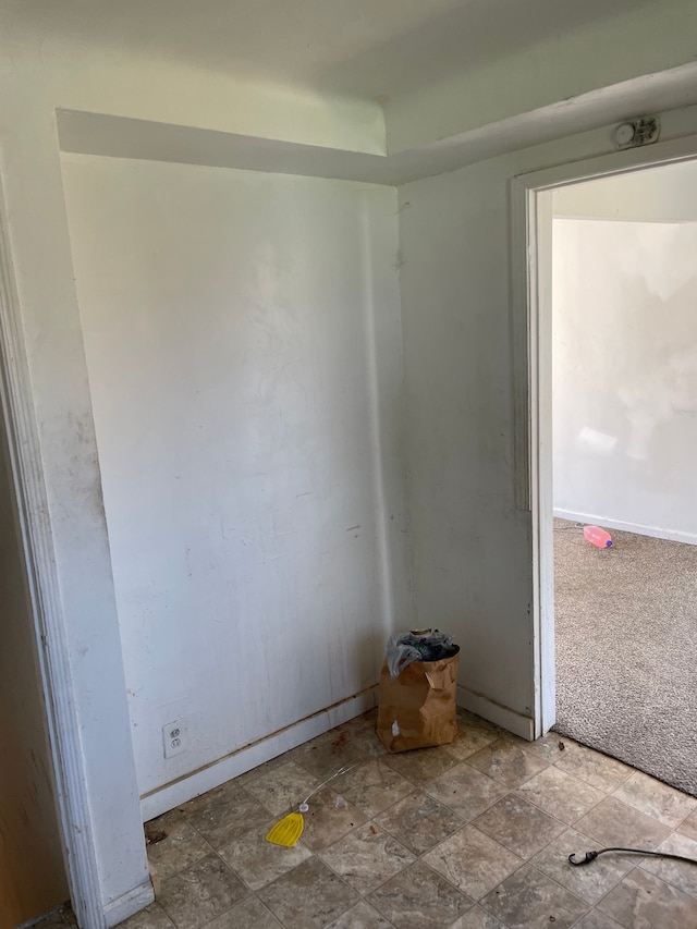 unfurnished room featuring baseboards and stone finish floors