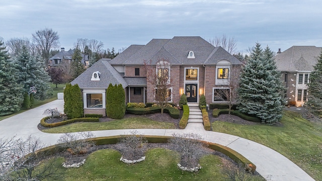 47490 Bellagio Dr, Northville, MI 48167 - french country style house with brick siding, curved driveway, a front lawn, and a shingled roof