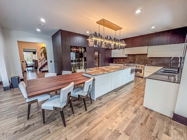 47490 Bellagio Dr, Northville, MI 48167 - kitchen with a sink, high end stainless steel range, a center island, modern cabinets, and under cabinet range hood