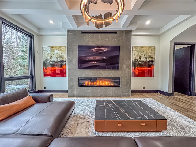 47490 Bellagio Dr, Northville, MI 48167 - living room with coffered ceiling, a large fireplace, wood finished floors, baseboards, and beamed ceiling
