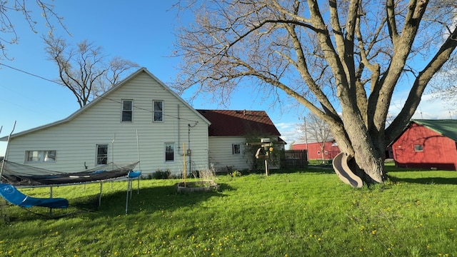 view of home's exterior featuring a trampoline and a lawn