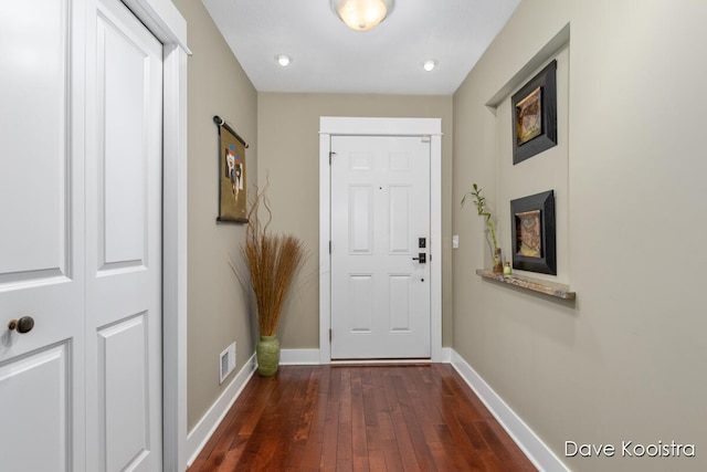 doorway featuring dark wood-style floors and baseboards