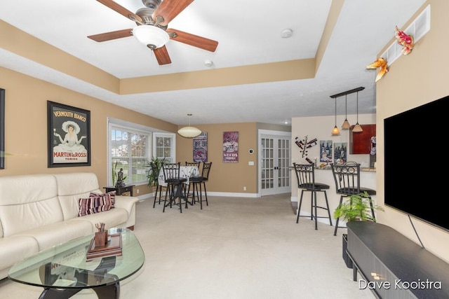 living room with light colored carpet, a ceiling fan, baseboards, and french doors