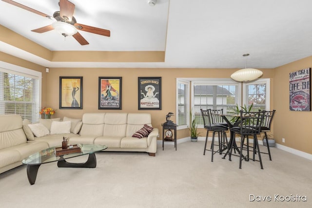 living area featuring baseboards, plenty of natural light, and carpet flooring
