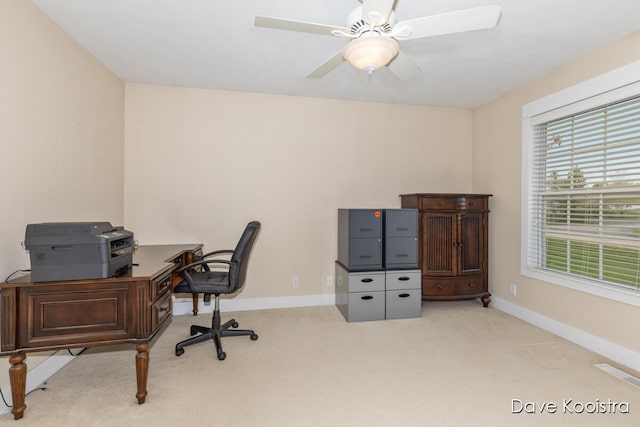 carpeted home office featuring baseboards and a ceiling fan