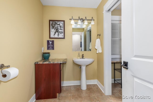bathroom with baseboards and a sink