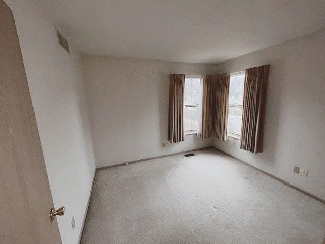 carpeted spare room featuring baseboards