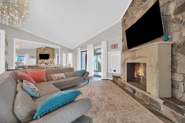 living area with a high end fireplace, a chandelier, ornamental molding, wood finished floors, and high vaulted ceiling