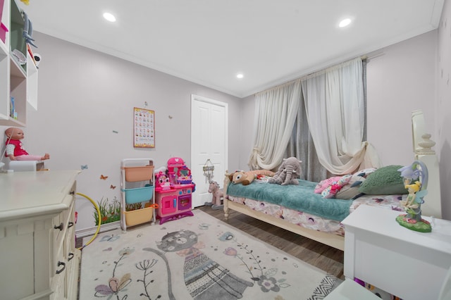 bedroom with crown molding, recessed lighting, wood finished floors, baseboards, and a closet