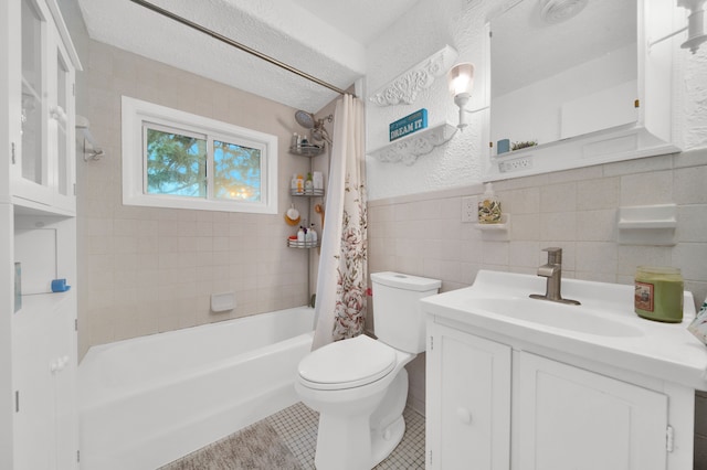 full bath featuring tile walls, toilet, shower / bath combo, vanity, and tile patterned floors