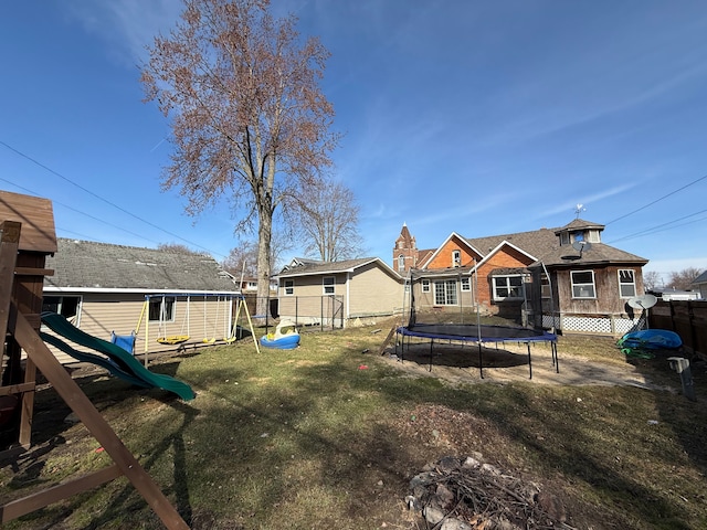 4235 Vine St, Brown City, MI 48416 - rear view of house with a trampoline, a playground, and brick siding