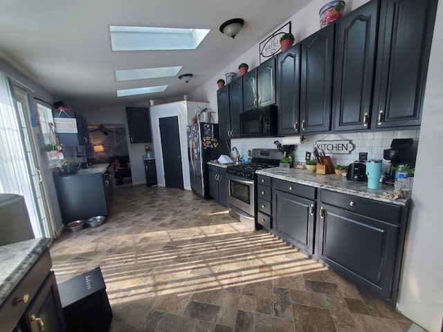 4235 Vine St, Brown City, MI 48416 - kitchen with stainless steel appliances, a skylight, dark stone finish flooring, tasteful backsplash, and light stone counters