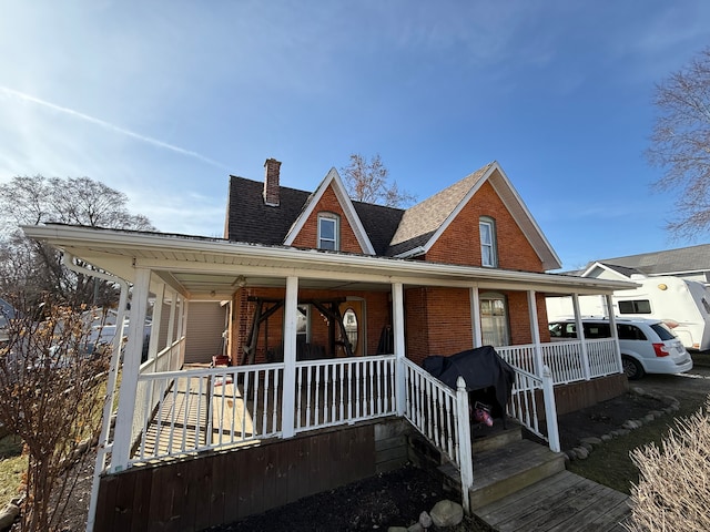 4235 Vine St, Brown City, MI 48416 - view of front of house featuring brick siding, a chimney, and covered porch