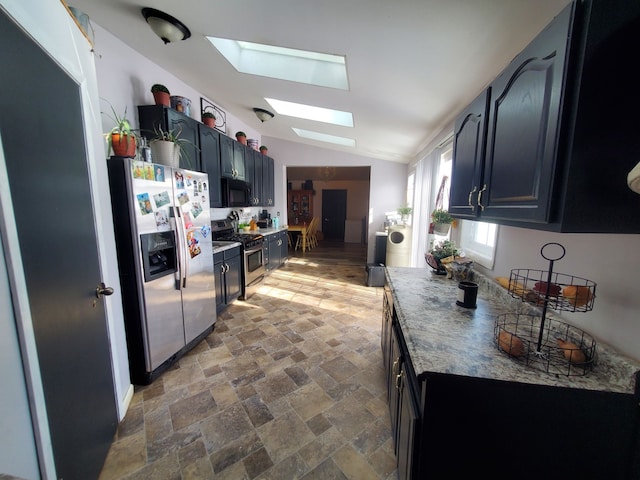 4235 Vine St, Brown City, MI 48416 - kitchen with appliances with stainless steel finishes, a skylight, vaulted ceiling, stone finish floors, and dark cabinets