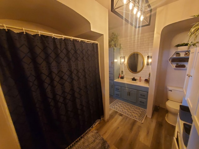 4235 Vine St, Brown City, MI 48416 - full bathroom featuring wood finished floors, decorative backsplash, toilet, vanity, and a shower with curtain