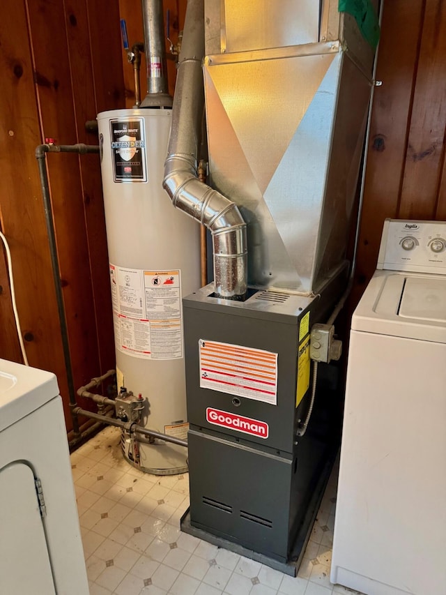 utilities featuring water heater, heating unit, and washing machine and clothes dryer