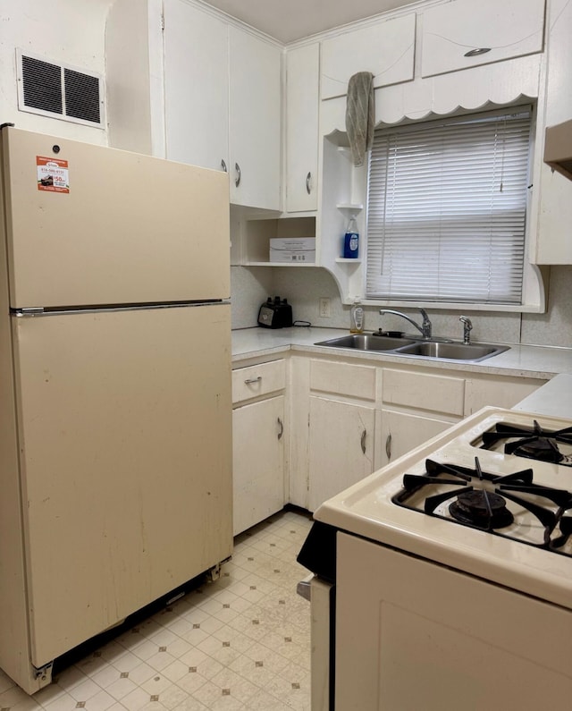 kitchen featuring white appliances, light floors, a sink, and light countertops