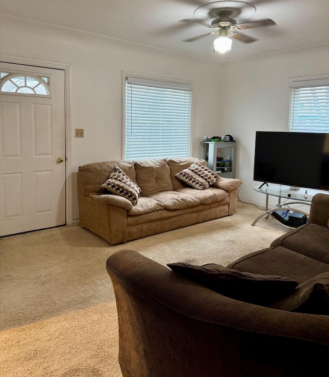 living area featuring light carpet and a ceiling fan