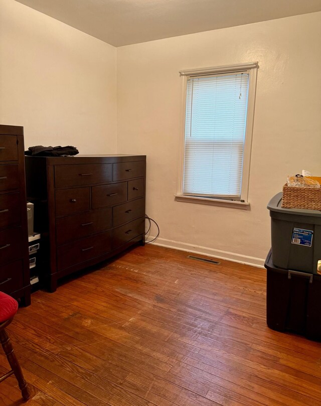 bedroom featuring hardwood / wood-style flooring and baseboards