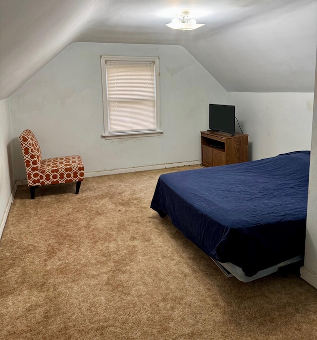 carpeted bedroom featuring lofted ceiling and baseboards