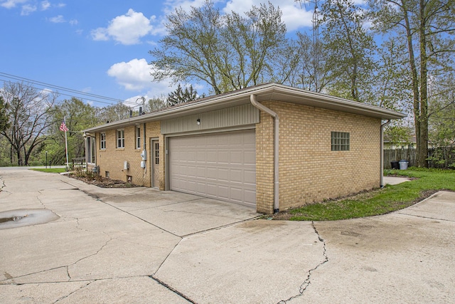 2228 Washington Ave, Saint Joseph, MI 49085 - view of side of home with concrete driveway, brick siding, and an attached garage