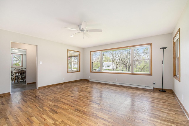 2228 Washington Ave, Saint Joseph, MI 49085 - empty room with a baseboard heating unit, plenty of natural light, light wood-style flooring, and a ceiling fan
